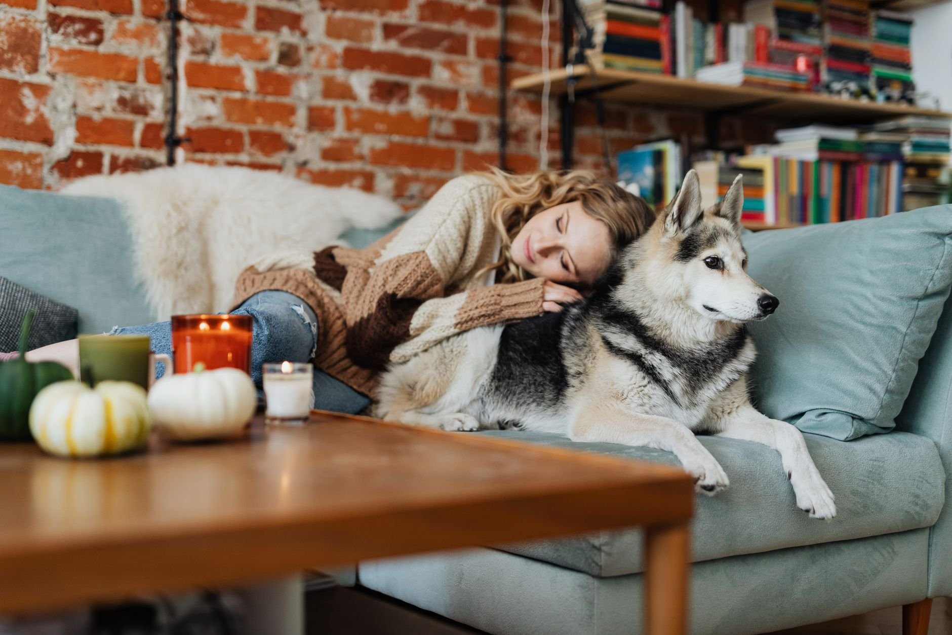 Woman resting with her dog in a cosy living room setting, evoking warmth and comfort.